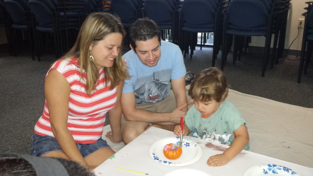 child painting pumpkin