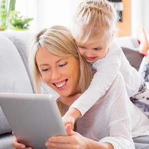 child with grown up enjoying virtual classes